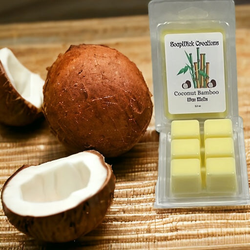 Yellow coconut bamboo scented wax melt sitting on a bamboo mat with Coconut beside it.