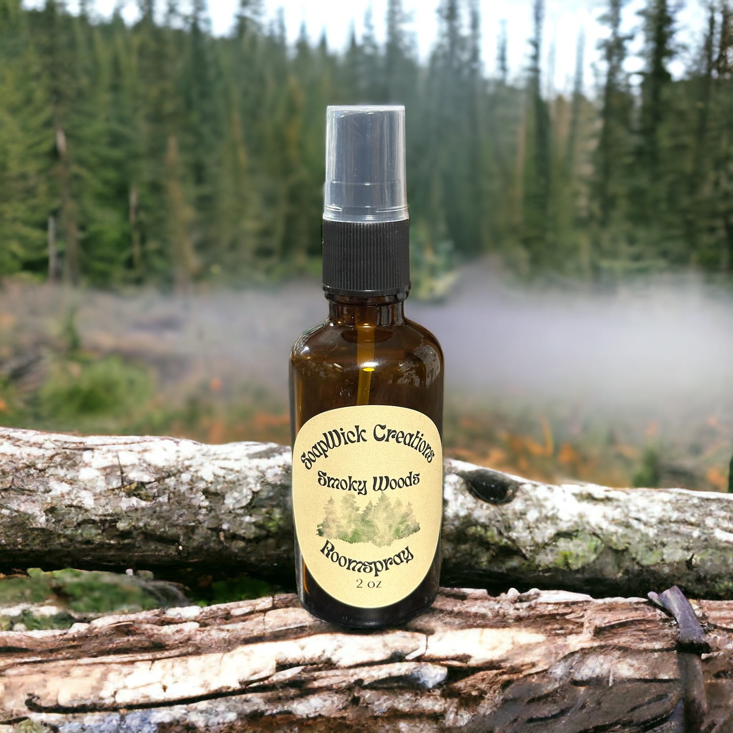 Photograph of a 2 ounce spray bottle containing “Smoky Woods” fragrance oil, Sitting on a log with a smoky forest in the background.