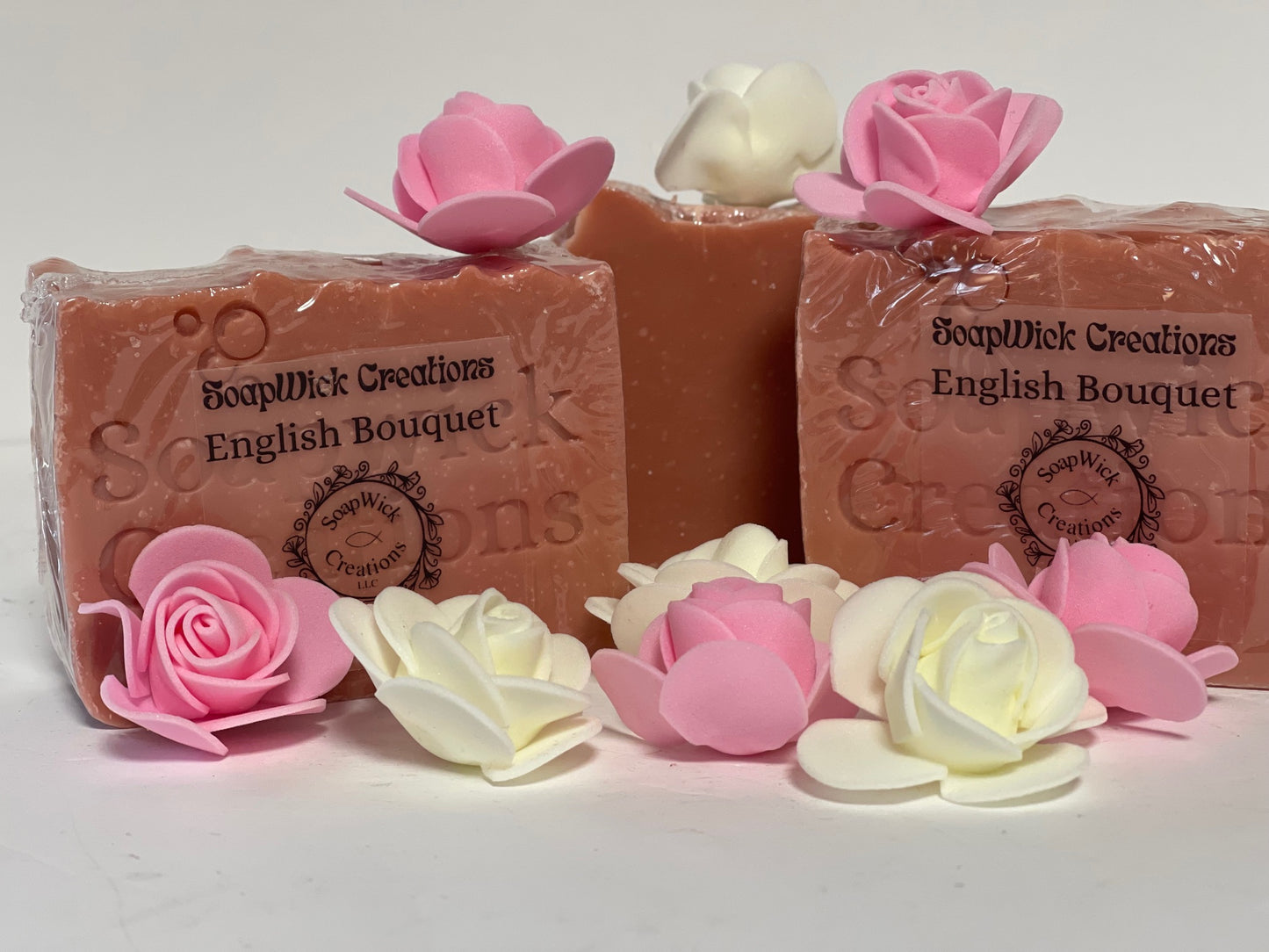 Photo of English bouquet floral, scented soaps with paper roses as decoration in front of an on top of the soaps.