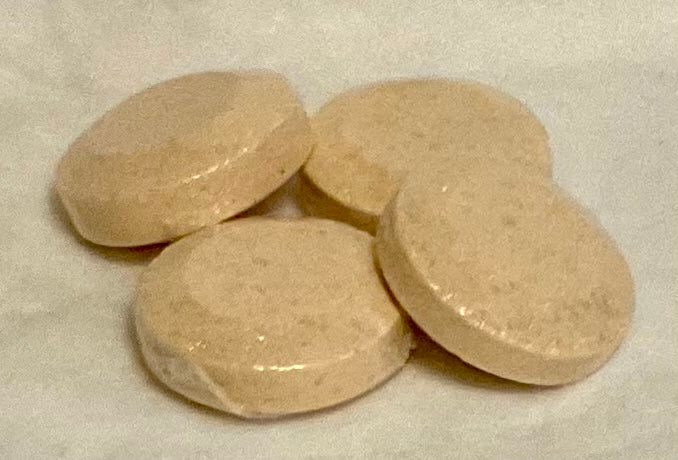 Photograph of disc shaped shower steamers, beige in color scented in Peppermint and Menthol.