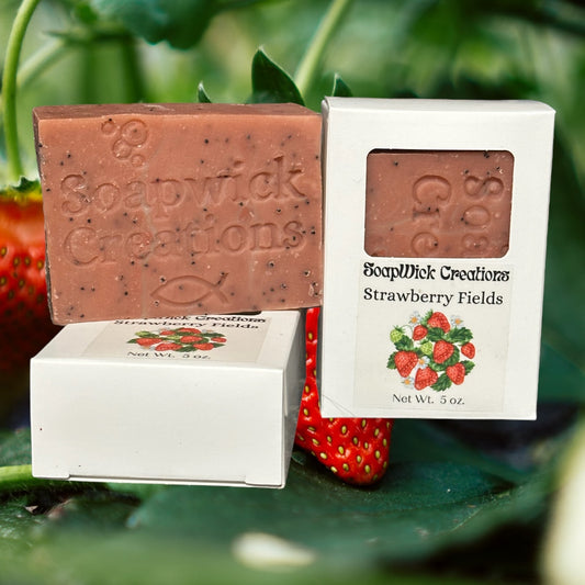 Bars of strawberry scented soap with a field of strawberries in the background.