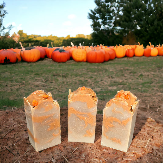 3 Orange and beige Pumpkin Spice bars of soap with a pumpkin patch in the background.