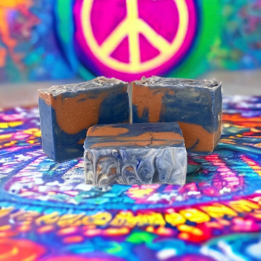 Photo of red and blue Hippie Chickie soap on a psychedelic surface with psychedelic surface and peace sign in the background.