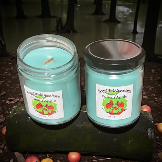 Two teal candles in jars sitting on a moss covered stump in a gloomy looking swamp forest.