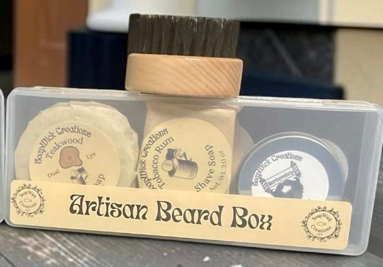 Two boxed beard grooming sets displayed on a wooden table outside a barbershop, with a red, white, and blue barber pole and shop facade blurred in the background.