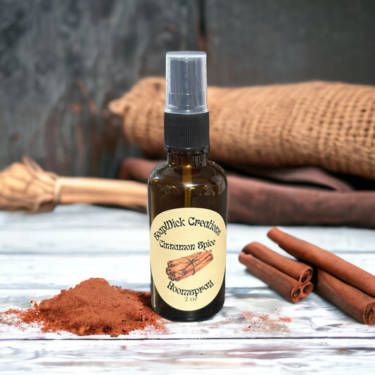 Photograph of a 2 ounce spray bottle containing cinnamon spiced fragrance sitting on a table with cinnamon, cinnamon sticks and burlap in the background.