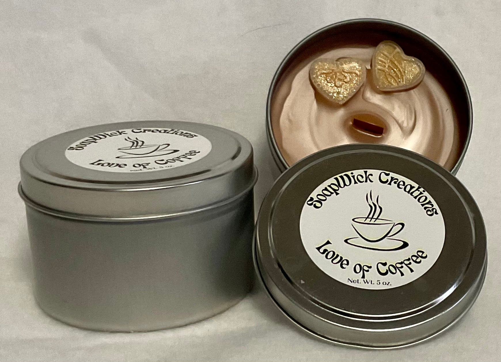  Photo of a light brown candle with heart, embeds and coffee scent in a silver tin