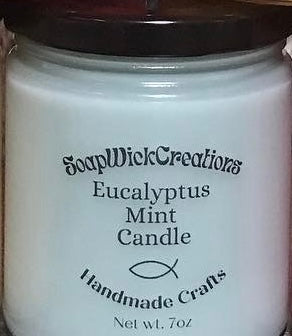 Photograph of a candle with light green, coconut wax and scented with eucalyptus mint fragrance.